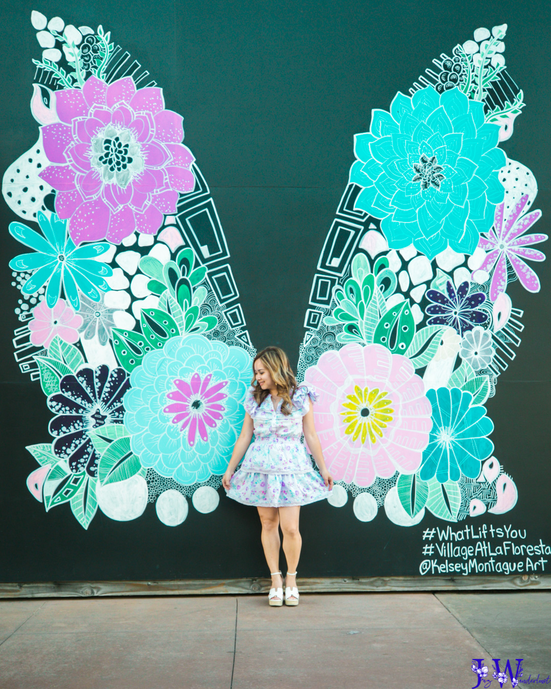 Wearing Love Shack Fancy and standing in front of the kelsey montague butterfly wings in brea