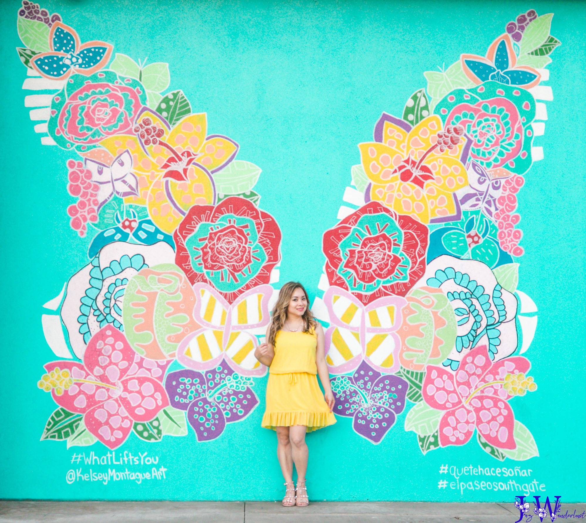Wearing a yellow dress standing in front of Kelsey Montague butterfly wings at El Paseo South Gate in Los Angeles